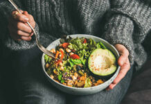Vegan Diets Under Fire — Cancer Risk EXPOSED! A person holding a bowl of colorful salad with avocado and greens