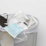 Air Pollution Quietly Stealing Your Bone Health A trash bin filled with various discarded face masks