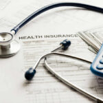 Migrant Health Revolution: 7 Nations Lead the Way Stethoscope and calculator on health insurance documents