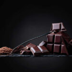 Chocolate’s Hidden Heart Benefits: What’s the Catch? A pile of dark chocolate bars with cocoa powder on a black surface