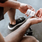 Midlife Muscle Crisis: Are You at Risk? Person pouring probiotic pills into their hand