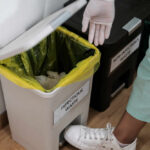 The Calcium Powerhouse Hidden in Your Trash Person in gloves disposing of waste in an infectious waste bin