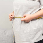 The Surprising Weight-Loss Hack Person measuring their waist with a tape measure