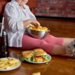 Bone-Risking Foods You Eat Daily Child sitting on the floor enjoying snacks from a bowl