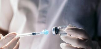 A healthcare professional preparing a syringe from a vial