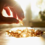 Liver Breakthrough: Common Vitamin’s Secret Power A hand reaching for a golden capsule among many on a table
