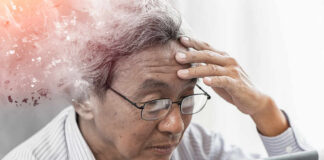 Elderly man looking stressed while using a digital device