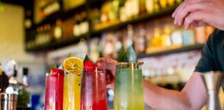 A bartender preparing colorful cocktails at a bar