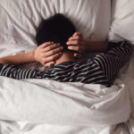 Gut Disruptions That Ruin Your Sleep Child lying in bed with hands over ears