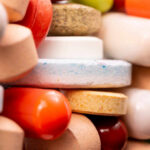 Drug That Quietly Crushes Your Cravings and Addictions A close-up view of a variety of colorful pills and tablets stacked together