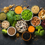 Weird Veggies, Best Gut Upgrade An assortment of legumes, nuts, and fresh vegetables arranged in bowls on a dark surface