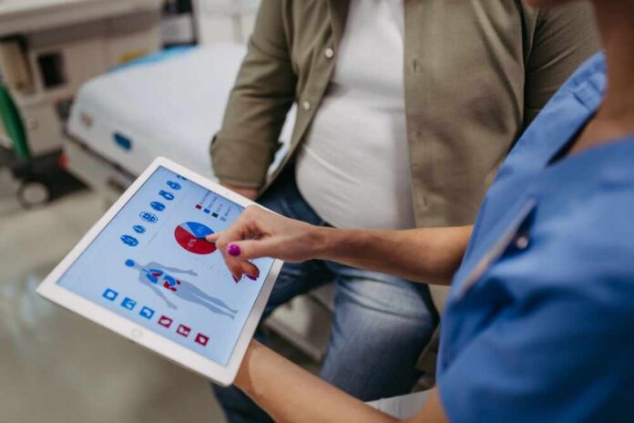 Close,Up,Of,Female,Doctor,Consulting,With,Overweight,Patient,,Discussing Nurse showing a patient health data on a tablet