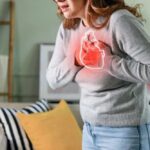 Heartburn? Or Heart Attack? Woman holding her chest in discomfort with a heart illustration