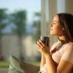 Tea Lovers Stunned By Dose Twist Woman enjoying a cup of coffee in a sunlit room