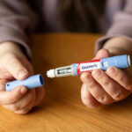 Weight Loss Drugs and Heart Disease Risk Hands holding an Ozempic injection pen.