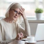 Ways to Improve Your Memory and Cognitive Function at Any Age Older woman with glasses looking concerned at laptop