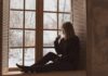 Gold Standard Treatment for Winter Depression Person sitting on a windowsill looking outside