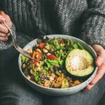 Veggie ‘Microplastic Detox’ Hype — Science Says Wait person holding a bowl of salad with avocado