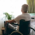 Disease and Aging: Why Quiet Damage Bites You Way Later older man in a wheelchair looking out a bright window