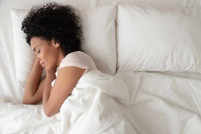 shutterstock_1444222010 Woman sleeping on white bedding