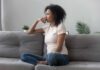 Woman sitting on a gray sofa looking thoughtful