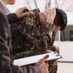 Global Mental Health Crisis – Staggering Numbers! Soldier in camouflage sits with head in hands during counseling session