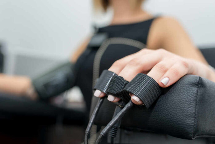 Woman,With,Light,Hair,,Dressed,In,Black,Dress,-,Polygraph, Close-up of a patients hand during a medical examination with monitoring equipment