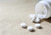 Weight-Loss Drug Twist: Your Steps Plunge? White tablets spilling from a plastic bottle