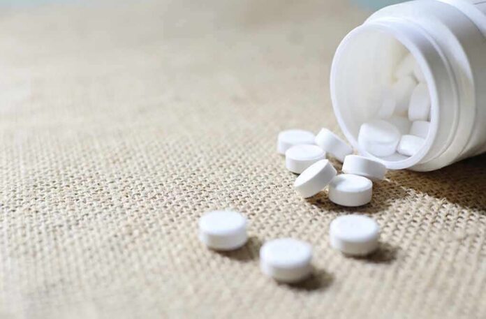 White tablets spilling from a plastic bottle