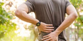 person holding lower back outdoors