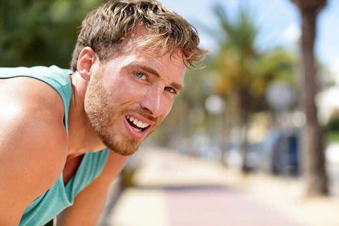 shutterstock_1017406066 man in athletic tank top resting outdoors