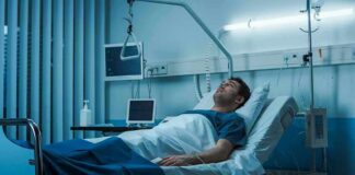 Man lying in a hospital bed with monitors and IV equipment
