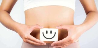 torso of person holding smiley card over stomach