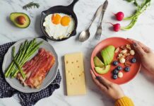 Breakfast spread with bacon, asparagus, eggs, avocado, berries, nuts, and cheese