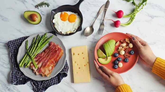 Breakfast spread with bacon, asparagus, eggs, avocado, berries, nuts, and cheese
