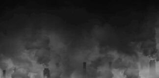 Factory smokestacks emitting thick smoke in heavy smog