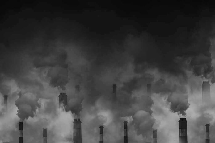 Factory smokestacks emitting thick smoke in heavy smog
