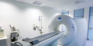 A CT scanner in a hospital room with medical equipment nearby