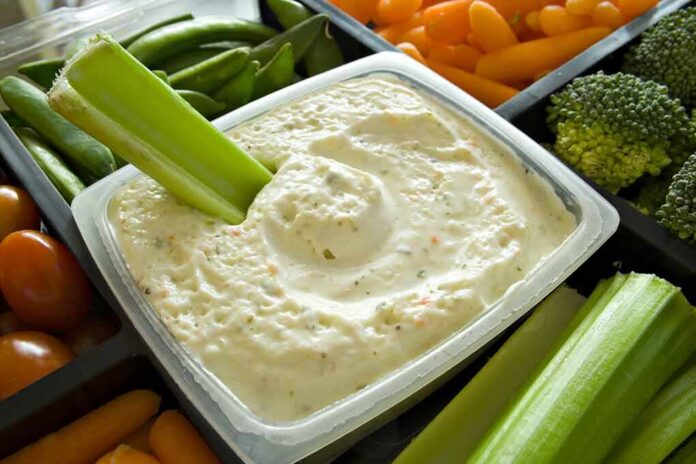 shutterstock_2619259 Celery dipped in creamy vegetable dip in a tray of fresh veggies