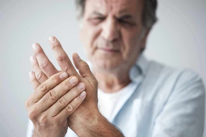 Man holding his hand in discomfort