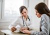 Longevity Hack Hiding In Boring Checkup Markers Doctor consulting a patient at a desk