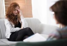 WHO-Backed Routine Calms Brain Storms Woman with hand on forehead sitting on couch during counseling session
