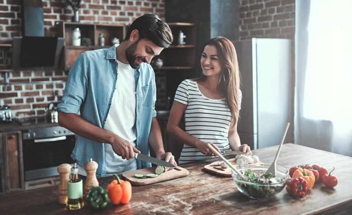 shutterstock_1145475803 Couple preparing vegetables together in a rustic kitchen