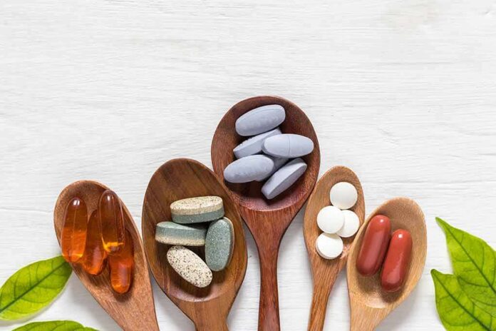 shutterstock_1167230344-1 Assorted dietary supplements on wooden spoons