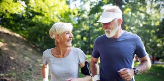 older couple jogging together in a sunny park