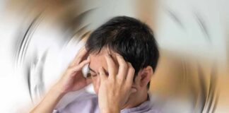 Person holding head with spinning blur effect