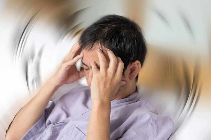 Person holding head with spinning blur effect