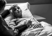 Fever vs. Heatstroke: One Deadly Mistake Patient in hospital bed with nasal oxygen held by visitor