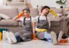 Bacteria Bomb Hiding In Daily Home Essentials Two tired cleaners sitting on the floor by a sofa