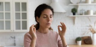 Woman meditating with closed eyes in a kitchen